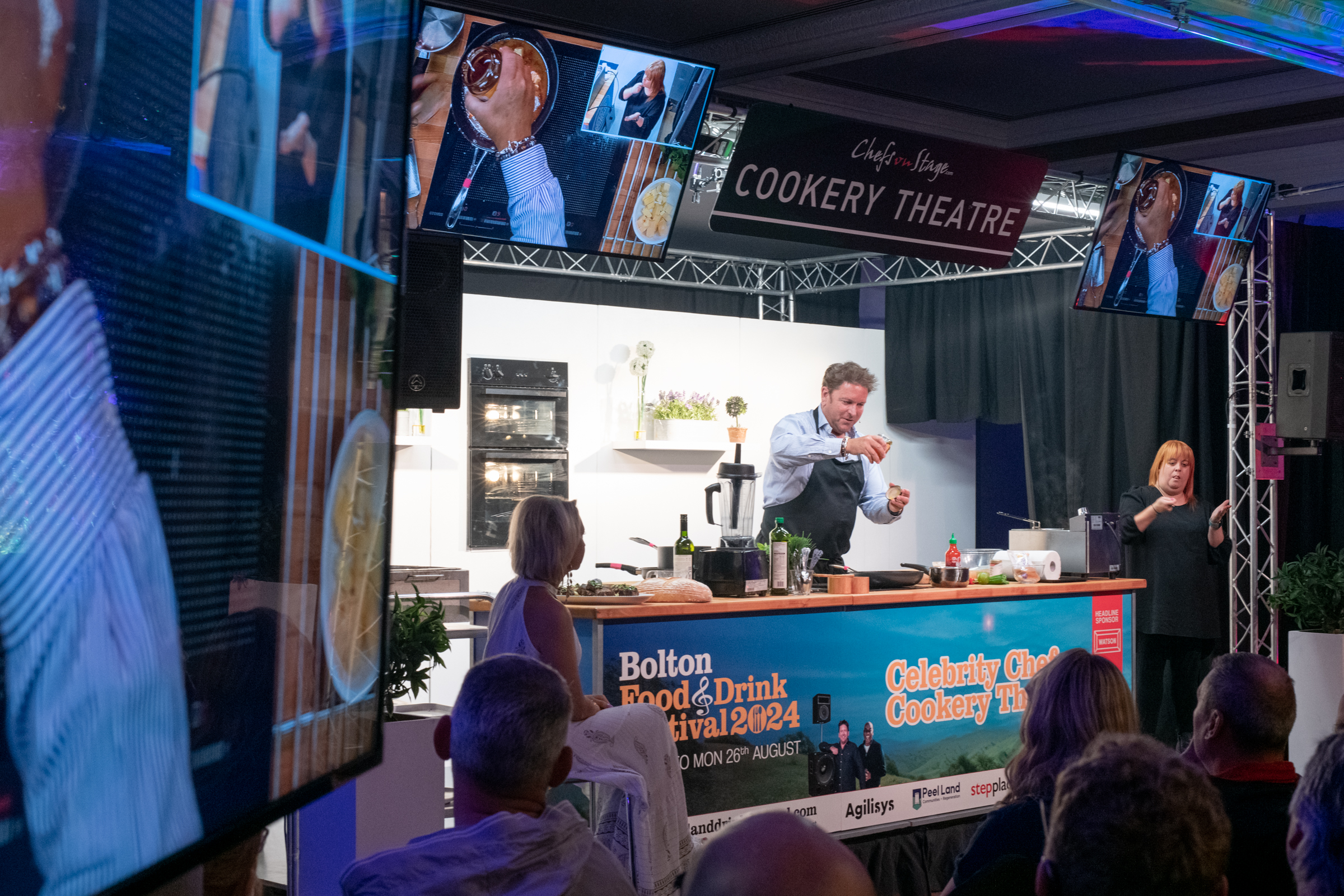 Man performing a cooking show to a large audience